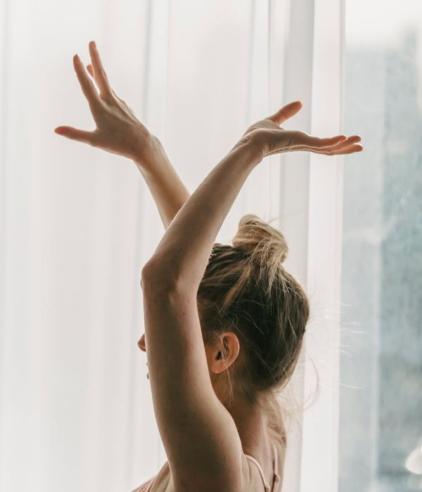 Woman in a graceful stretching yoga pose with soft light.